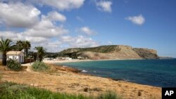 FILE - A view of the coastline in Praia da Luz, in Portugal's Algarve coast, on June 4, 2020. Portuguese police say they'll resume searching for Madeleine McCann, the British toddler who disappeared in the country's Algarve region in 2007.