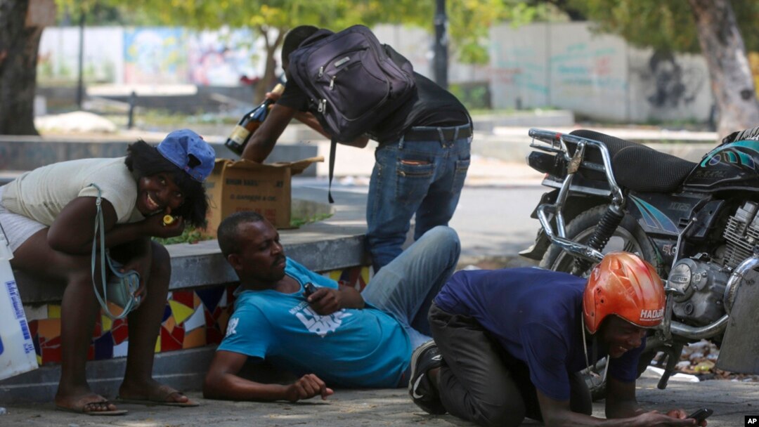 Orang-orang berlindung dari tembakan saat bentrokan antara polisi dan geng di kawasan Champs de Mars sebelah Istana Nasional di Port-au-Prince, Haiti, 8 April 2024.