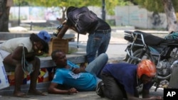 Orang-orang berlindung dari tembakan saat bentrokan antara polisi dan geng di kawasan Champs de Mars sebelah Istana Nasional di Port-au-Prince, Haiti, 8 April 2024.