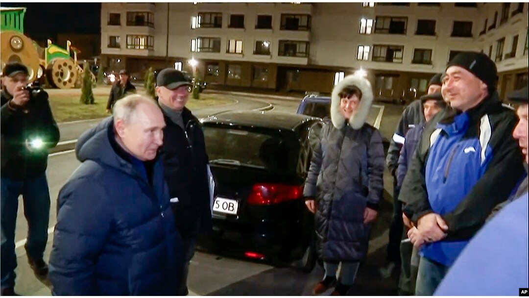 Presiden Rusia Vladimir Putin berbicara dengan penduduk setempat selama kunjungannya ke Mariupol di wilayah Donetsk yang dikuasai Rusia, Ukraina. (Foto: via AP)