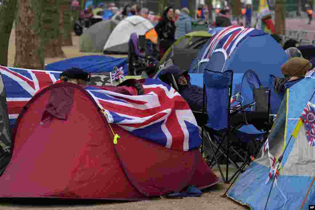 Royal fans who have spent the night camping out along the Mall, part of the Coronation route, wake up and leave their tents in London.