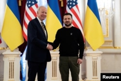 Presiden AS Joe Biden berjabat tangan dengan Presiden Ukraina Volodymyr Zelenskiy di Istana Mariinsky dalam kunjungan mendadak di Kyiv, Ukraina, Senin, 20 Februari 2023. (Evan Vucci/Pool via REUTERS)