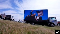 Електронски билборд ја прикажува фотографијата од Трамп после пукањето врз него