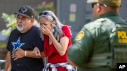 FILE - A woman cries as she leaves the Uvalde Civic Center after a school shooting at Robb Elementary School, May 24, 2022, in Uvalde, Texas.