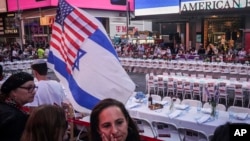 FILE - Israeli Americans and their supporters are seen at an installation in Times Square, featuring symbolic tables set for hostages held captive by Hamas in the Gaza Strip, Oct. 26, 2023, in New York.