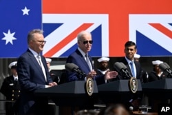 조 바이든 미국 대통령(사진 중앙)이 2023년 3월 미국 샌디에이고에 있는 한 해군 기지에서 리시 수낙 영국 총리(사진 맨 오른쪽), 그리고 앤서니 알바니즈 호주 총리(사진 맨 왼쪽)와 함께 AUKUS 협정 체결을 발표하고 있다. (자료사진)