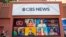 FILE - People pass the CBS Broadcast Center on 57th Street in New York, April 20, 2023. CBS News has asked all its local stations to become proficient in solutions journalism.
