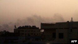 Smoke billows behind buildings in southern Khartoum, on May 27, 2023, amid ongoing fighting between the forces of two rival generals.