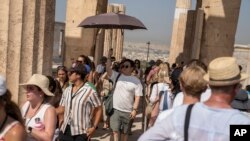 FILE - A crowd of tourists visit the Acropolis, in Athens, Greece, July 13, 2023. 