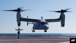 FILE - A Royal Australian Navy sailor guides a U.S. Marine Corps MV-22 Osprey during take-off and landing practice on the flight deck of HMAS Adelaide off the coast of Australia, Aug. 7, 2023. (SGT Andrew Sleeman/Royal Australian Navy via AP)