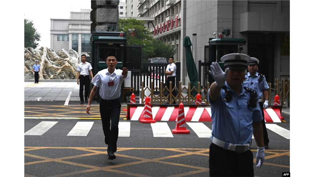 中国警察与保安人员在举行中共三中全会的京西宾馆外执勤时做禁止手势。(2024年7月15日)