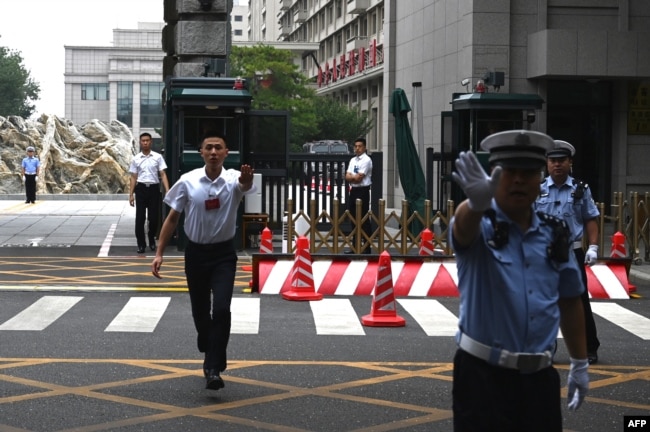 中国警察与保安人员在举行中共三中全会的京西宾馆外执勤时做禁止手势。（2024年7月15日）