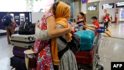 Researcher and women's rights activist Naveen Hashim, right, embraces a documentary journalist upon her arrival with four other Afghan women and three children at the Roissy-Charles de Gaulle airport north of Paris on Sept. 4, 2023.