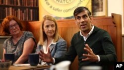 British Prime Minister Rishi Sunak and Katy Bourne, Sussex police and crime commissioner, second left, meet with Neighbourhood Watch representatives in Horsham, south of London, June 10, 2024, ahead of a campaign event for the July 4 election. (Pool/AP)