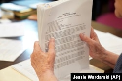 Sister Barbara McCracken reviews previous resolutions filed against various companies, including Alphabet, Meta, Netflix and Chevron, at the Benedictine monastery of Mount St. Scholastica in Atchison, Kansas, Tuesday, July 16, 2024. (AP Photo/Jessie Wardarski)