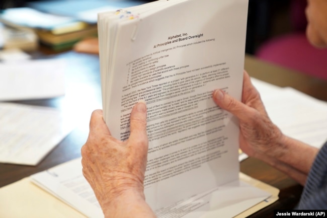 Sister Barbara McCracken looks through prior resolutions filed against various corporations, including Alphabet, Meta, Netflix and Chevron, at the Mount St. Scholastica Benedictine monastery in Atchison, Kan., Tuesday, July 16, 2024. (AP Photo/Jessie Wardarski)