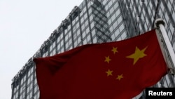 资料照片：中华人民共和国的国旗竖立在普华永道分部所在的北京一座大楼前。 (2014年1月24日)