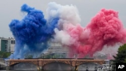 Ceremonial smoke in the colors of the France flag appear over the Seine River in Paris, during the opening ceremony of the 2024 Summer Olympics, July 26, 2024.