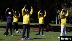 FILE - Falun Gong members exercise in Sydney, Australia, Aug. 28, 2020. Two Los Angeles residents have been charged with acting in a Beijing-directed scheme targeting U.S.-based practitioners of the Falun Gong group, which is outlawed in China.