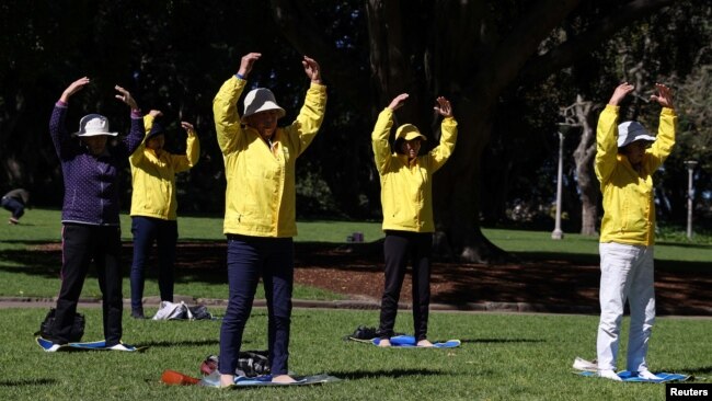 FILE - Falun Gong members exercise in Sydney, Australia, Aug. 28, 2020. Two Los Angeles residents have been charged with acting in a Beijing-directed scheme targeting U.S.-based practitioners of the Falun Gong group, which is outlawed in China.