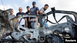 Palestinos inspeccionan un vehículo dañado por un ataque aéreo israelí en Zeta, Cisjordania, el 3 de agosto de 2024.