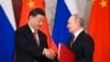 Russian President Vladimir Putin, right, and Chinese President Xi Jinping shake hands as they exchange documents during a signing ceremony following their talks at the Grand Kremlin Palace, in Moscow, Russia, March 21, 2023.