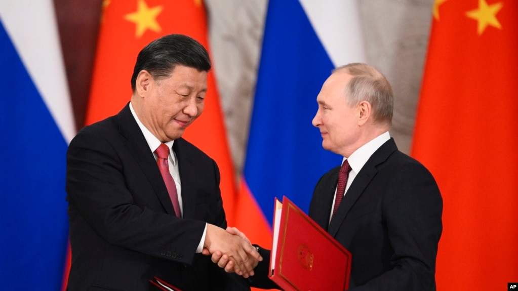 2023 年 3 月 21 日，俄罗斯莫斯科克里姆林宫，俄罗斯总统弗拉基米尔·普京（右）和中国国家主席习近平在会谈后的签字仪式上握手交换文件。(photo:VOA)
