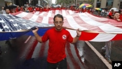 (FILE) Local 361 iron worker Robert Farula marches up Fifth Ave. carrying an American flag during the Labor Day parade on Sept. 8, 2012.