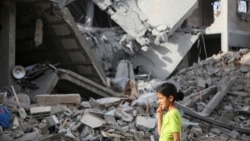25일 가자지구 남부 라파에서 이스라엘의 공습으로 무너져내린 건물 앞을 팔레스타인 난민 어린이가 지나가고 있다.