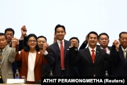 Pemimpin Partai Bergerak Maju, Pita Limjaroenrat bergandengan tangan dengan pimpinan partai koalisi usai pertemuan dengan mitra koalisi di Bangkok, Thailand, 18 Mei 2023. (Foto: REUTERS/Athit Perawongmetha)
