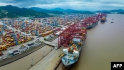 FILE - Cargo ships are loaded with containers in Ningbo, in China's eastern Zhejiang province, June 6, 2023.