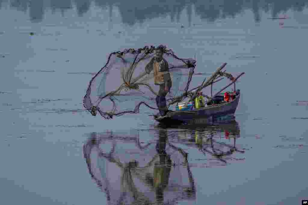 A Kashmiri fisherman casts his net into the waters of the Dal Lake on the outskirts of Srinagar, Indian-controlled Kashmir.