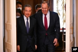 Diplomat senior China Wang Yi berbincang dengan Menlu Rusia Sergey Lavrov dalam kunjungan di Moskow (22/2).