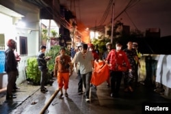 Tim penyelamat membawa kantong jenazah korban kebakaran di stasiun penyimpanan bahan bakar yang dioperasikan oleh Pertamina, di kawasan Plumpang, Jakarta, 3 Maret 2023. (REUTERS/Willy Kurniawan)