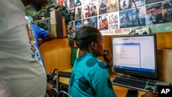 FILE: Representative illustration of an Internet cafe customer, right, using a computer in the Kibera neighborhood of Nairobi, Kenya Wednesday. Taken Sept. 29, 2021