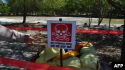 FILE - A warning is posted at a landmine site in the Trieu Phong district of Quang Tri province, Vietnam. About 6.1 million hectares of land in Vietnam remain blanketed by unexploded munitions decades after the war ended in 1975.
