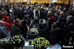 People attend a memorial ceremony for Dmytro Kotsiubailo, nom-de-guerre 'Da Vinci', former volunteer and serviceman, Hero of Ukraine, who was killed in a fight against Russian troops in the frontline town of Bakhmut, Ukraine March 9, 2023.