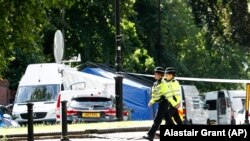 ARCHIVO - Patrulla policial afuera de Forbury Gardens, un día después de un ataque con apuñalamientos múltiples en los jardines de Reading, Inglaterra, el 21 de junio de 2020.