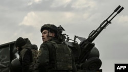 A Ukrainian serviceman stands in front of an anti-aircraft machine gun, in Siversk, Donbas region, March 7, 2023.