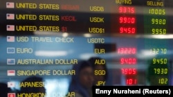 Sebuah papan elektronik berisi nilai tukar mata uang asing terpampang di tempat penukaran uang di Jakarta, 11 Juni 2013. (Foto: Enny Nuraheni/Reuters)