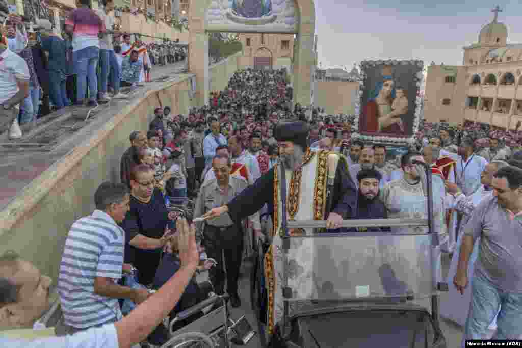 Coptic Bishop Uannas, the head of the Virgin Mary Monastery, blesses believers during a ceremonial procession to the cave church.