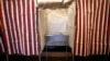 FILE - A booth is ready for a voter at City Hall in Cambridge, Mass., Feb. 24, 2020.