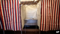 FILE - A booth is ready for a voter at City Hall in Cambridge, Mass., Feb. 24, 2020.