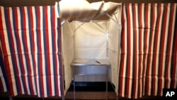 FILE - A booth is ready for a voter at City Hall in Cambridge, Massachusetts, Feb. 24, 2020. Russia-linked online accounts are disseminating divisive content aimed at influencing the upcoming U.S. presidential election, Microsoft said on April 17, 2024.