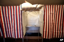 FILE - A booth stands ready for a voter at City Hall in Cambridge, Massachusetts, Feb. 24, 2020.