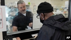 Pharmacist George Tadross takes care of a customer at MAC Pharmacy, May 29, 2024, in Cleveland. 