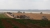 Israeli military vehicles roll near the border with the Gaza Strip on May 12, 2024.