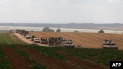 Israeli military vehicles roll near the border with the Gaza Strip on May 12, 2024.