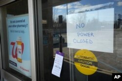 A no power closed sign is displayed at a Walgreens store in Detroit, Michigan, Feb. 24, 2023. The state is shivering through extended power outages caused by one of the worst ice storms in decades.