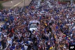 Presidential candidate Edmundo Gonzalez, center, and opposition leader Maria Corina Machado, center right, greet supporters during a campaign rally in Maracaibo, Venezuela, July 23, 2024.